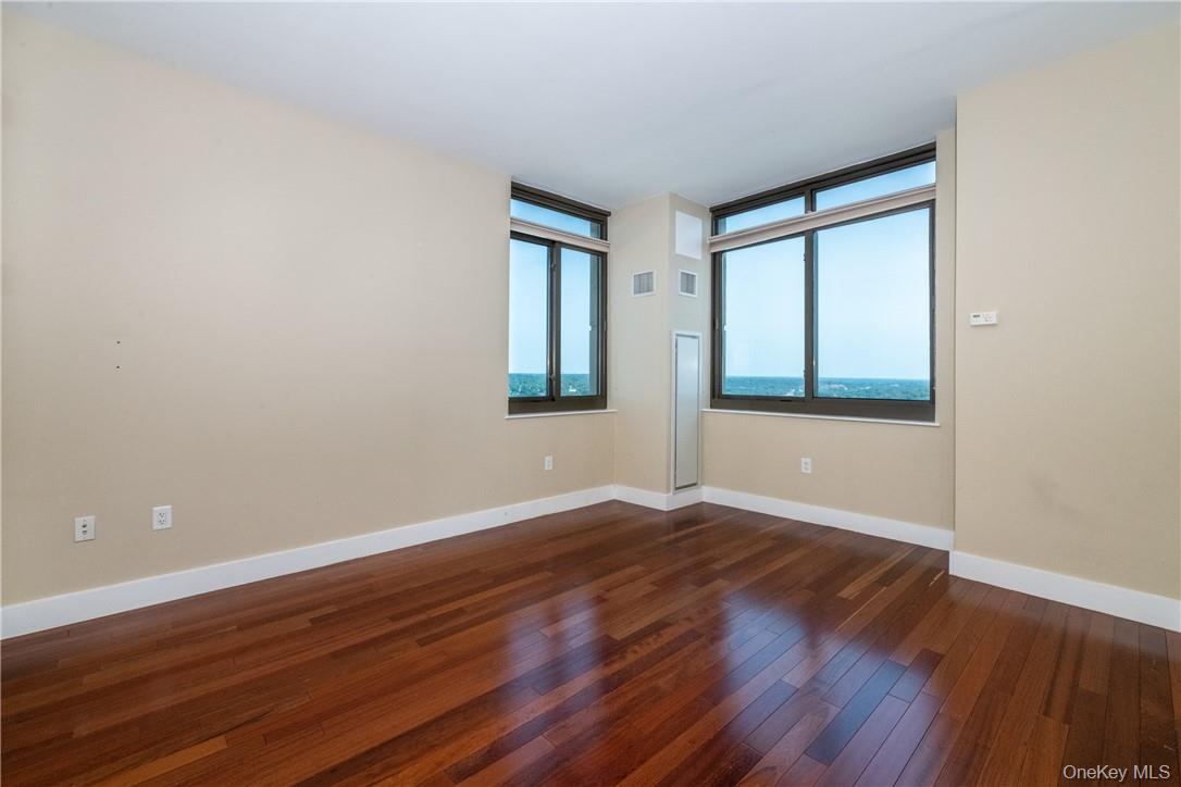 175 Huguenot Street, Unit 1802 New Rochelle, NY 10801 - Photo 16 of 31 an empty room with wooden floor and windows