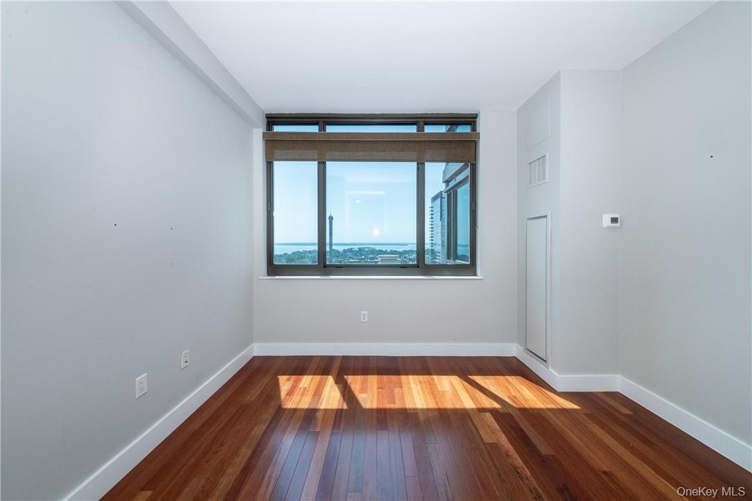 175 Huguenot Street, Unit 1802 New Rochelle, NY 10801 - Photo 21 of 31 a view of empty room with wooden floor and fan