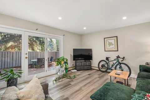 a living room with furniture a potted plant and a flat screen tv
