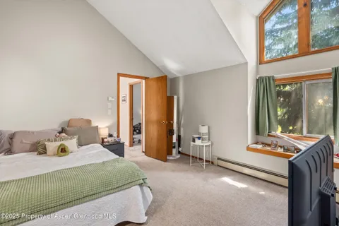 a bedroom with a bed and large windows