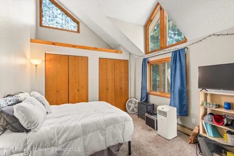 a bedroom with a bed a bookshelf and a window