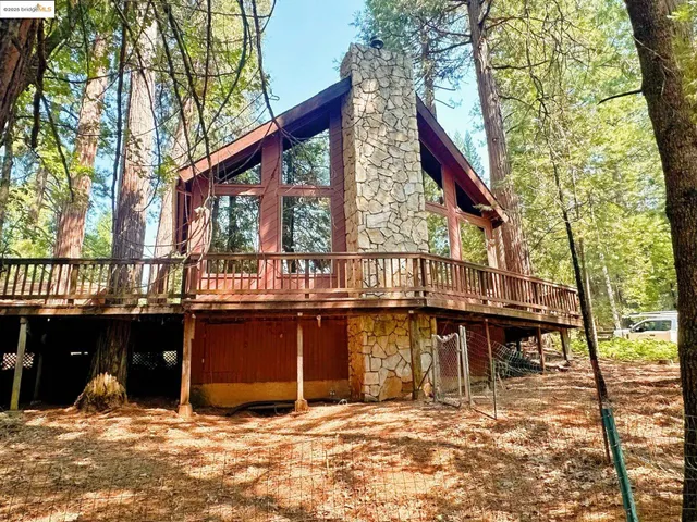 a backyard of a house with barbeque oven and outdoor seating