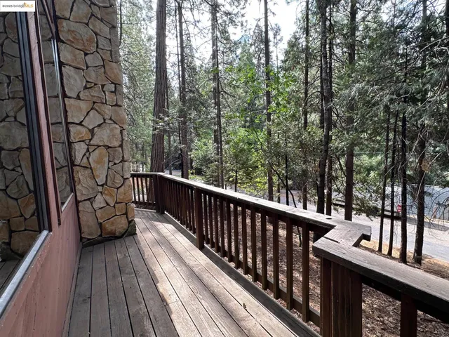 a balcony with wooden floor and wooden fence