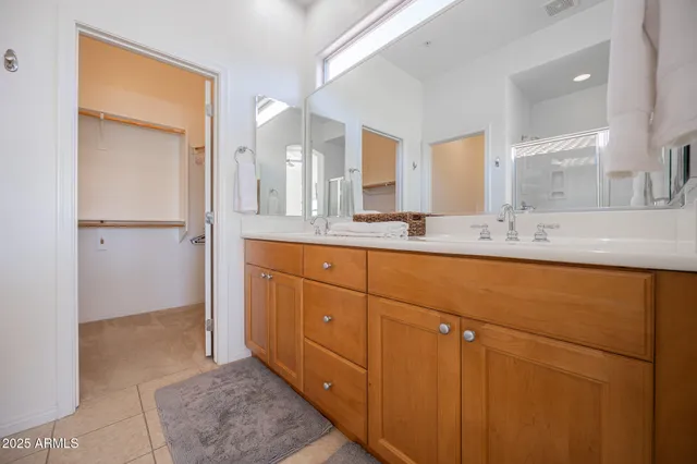 a bathroom with a granite countertop sink mirror and cabinets
