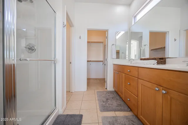a bathroom with a double vanity sink mirror and shower