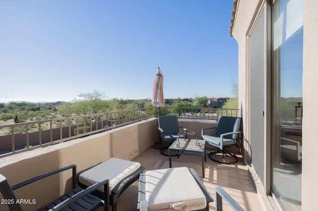 a view of a balcony with two chairs and a table