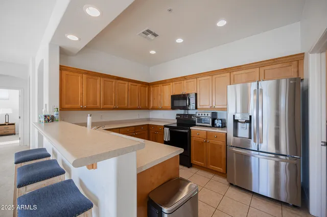 a kitchen with stainless steel appliances a refrigerator sink and cabinets