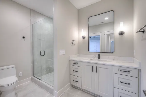 a bathroom with a granite countertop sink mirror and toilet