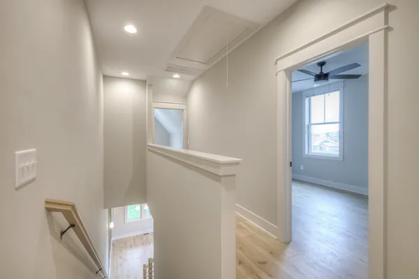 a view of hallway with stairs and wooden floor