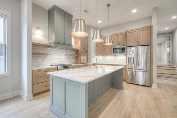 a kitchen with a sink stainless steel appliances and window
