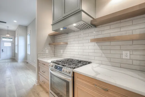 a kitchen that has a stove and a wooden floor