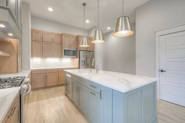 a kitchen with a sink refrigerator and cabinets