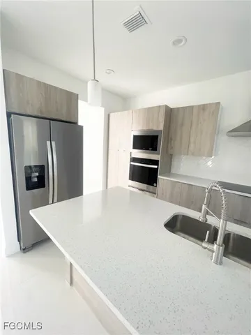 a kitchen with stainless steel appliances a refrigerator sink and white cabinets