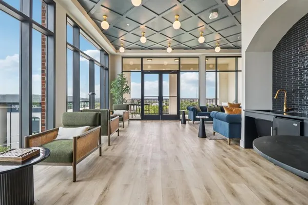 a living room with furniture a large window and wooden floor