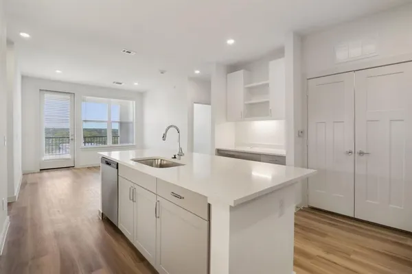 a kitchen with a sink stainless steel appliances furniture and a window