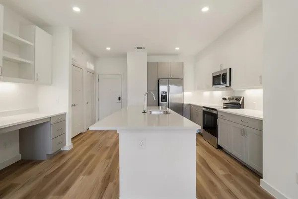 a large kitchen with kitchen island a sink stainless steel appliances and cabinets