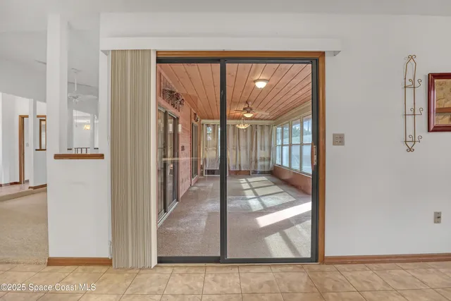 a view of a hallway with wooden floor and a living room