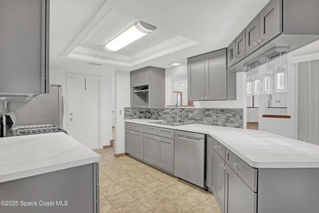 a kitchen with a sink a stove a refrigerator and white cabinets