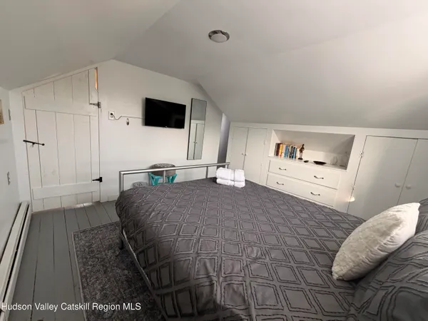 a bedroom with a bed and flat screen tv