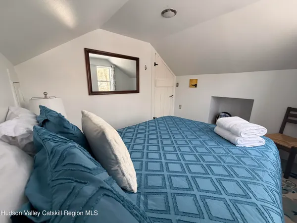 a bedroom with a bed and a painting on the wall