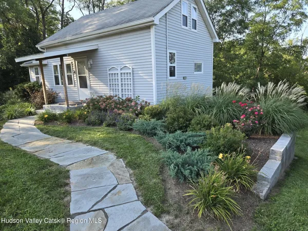 a front view of a house with a garden