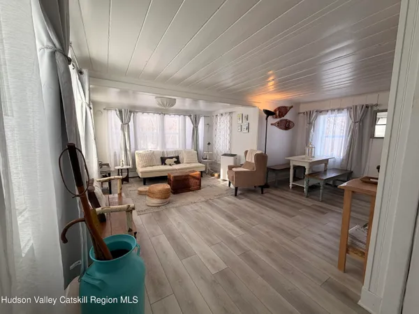 a living room with furniture a large window and wooden floor