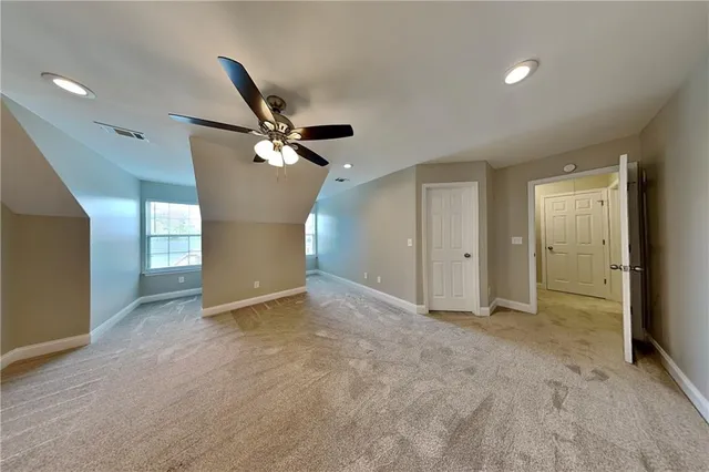 a view of an empty room with a ceiling fan