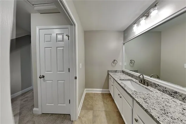 a spacious bathroom with a granite countertop sink and a mirror