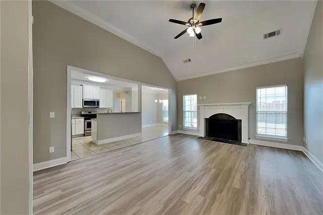 a view of empty room with wooden floor and fireplace