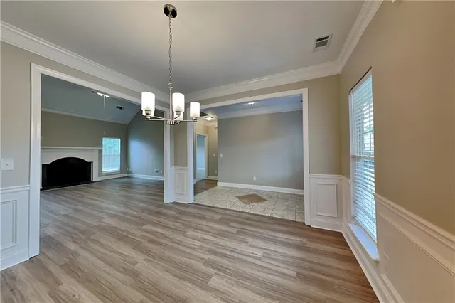 a view of a livingroom with a fireplace wooden floor and a chandelier