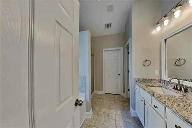 a spacious bathroom with a granite countertop sink a mirror and a shower