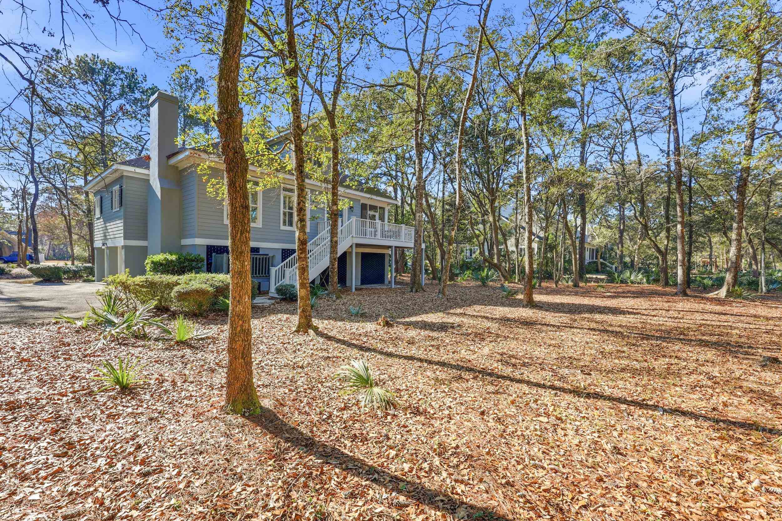 213 Old Carriage Loop Georgetown, SC 29440 - Photo 39 of 40 View of home's exterior featuring a deck, a chimney, stairs, and driveway