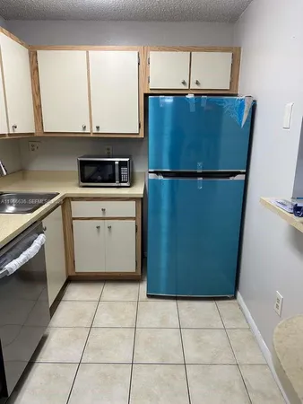 a kitchen with a refrigerator a stove a microwave and white cabinets