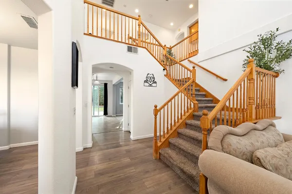 a kitchen with stainless steel appliances granite countertop a stove top oven a sink dishwasher a dining table and chairs with wooden floor