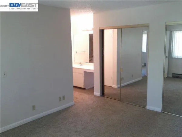 an empty room with windows and closet
