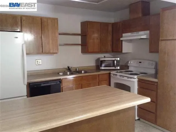 a kitchen with granite countertop a sink stainless steel appliances and cabinets