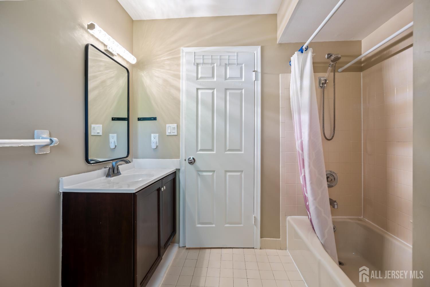 58 La Rue Lane East Brunswick, NJ 08816 - Photo 14 of 26 a bathroom with a granite countertop sink a mirror a bathtub and shower