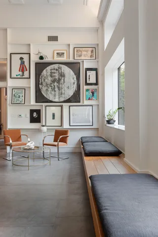 a living room with furniture and paintings on the wall