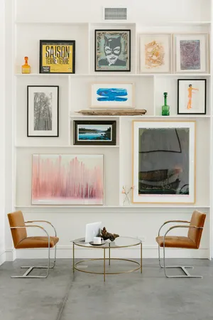 a living room with furniture and a painting on the wall