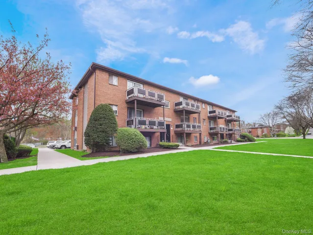 a view of a big building with a big yard and large trees