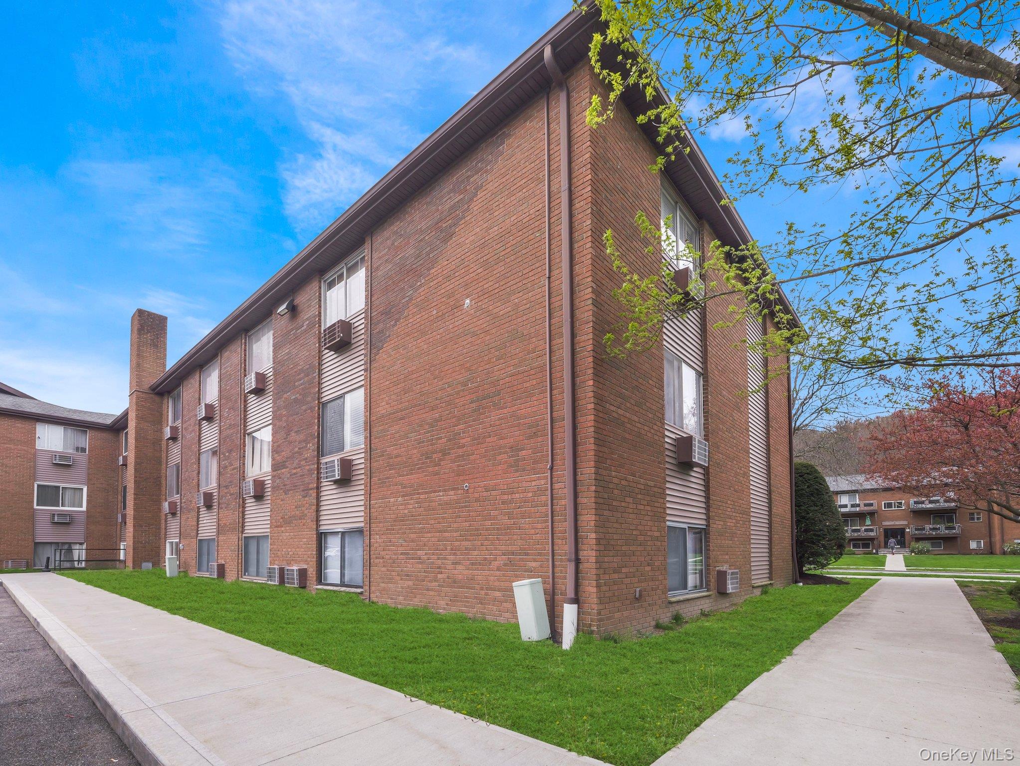 27 Tanager Road, Unit 2701 Monroe, NY 10950 - Photo 20 of 23 a view of a big building with a big yard and large trees