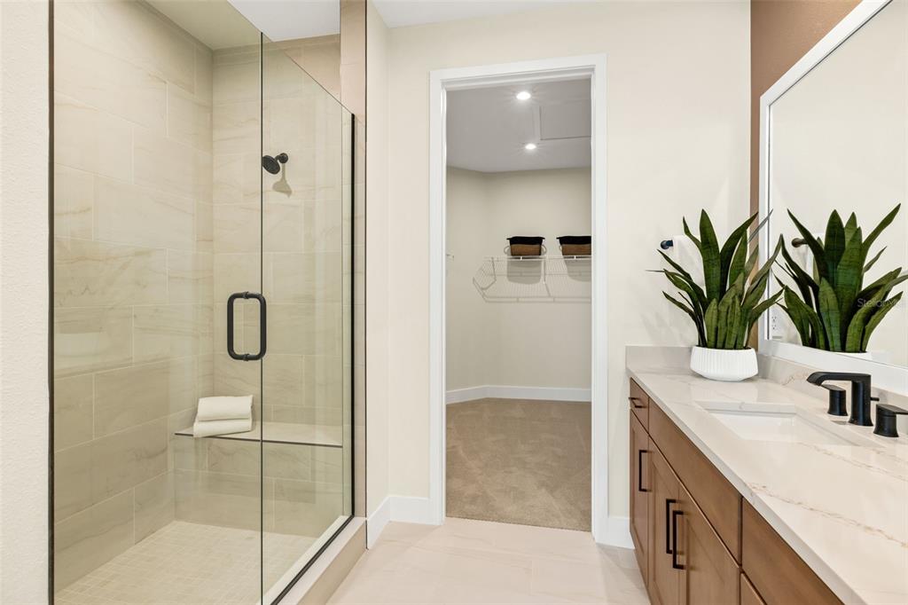 12829 Jade Empress Loop, Unit 201 Venice, FL 34293 - Photo 26 of 40 a bathroom with a granite countertop sink a shower and a mirror