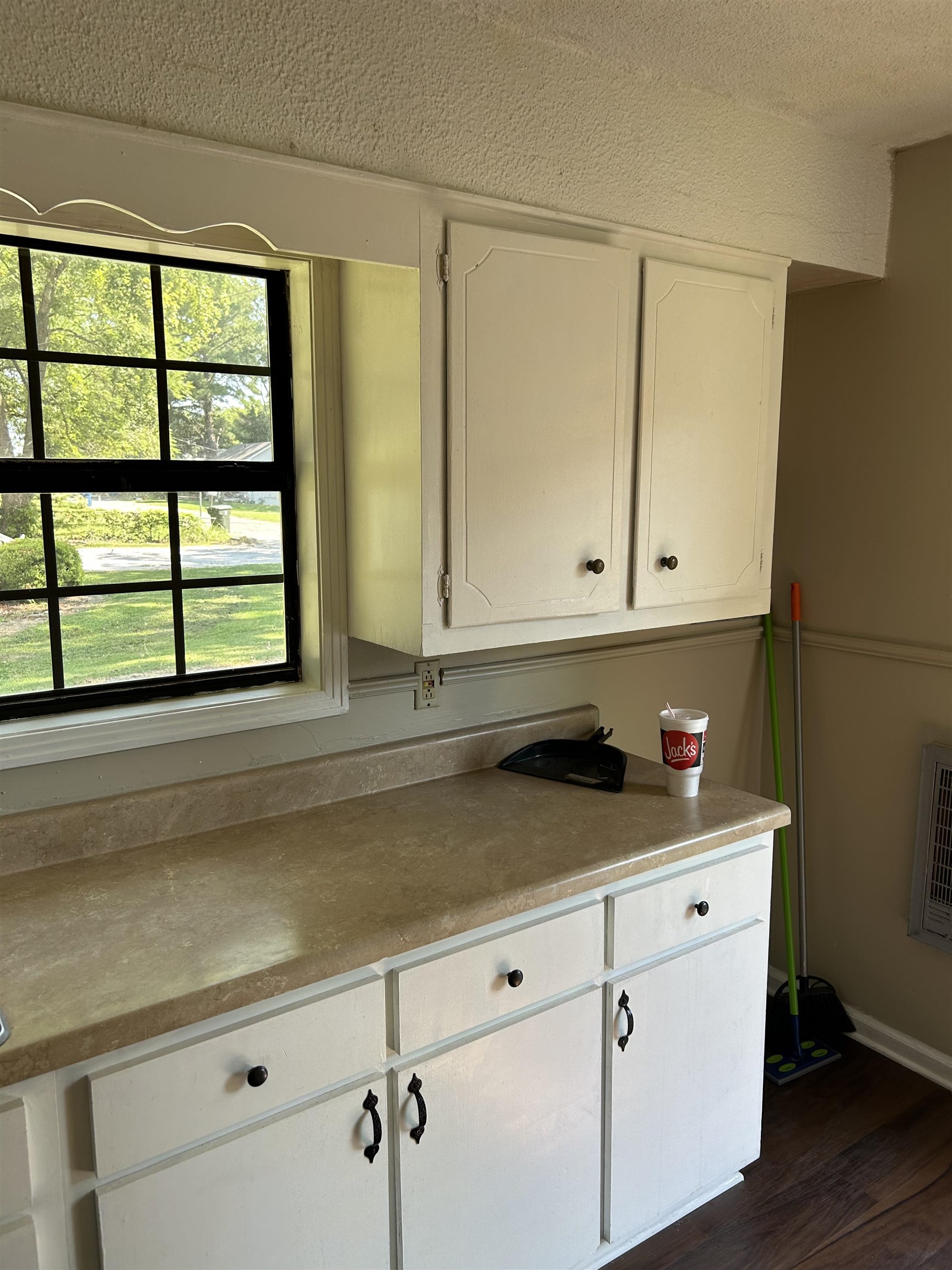 124 East Ripley Avenue Covington, TN 38019 - Photo 3 of 9 Kitchen with white cabinets, dark wood-type flooring, a textured ceiling, and light countertops