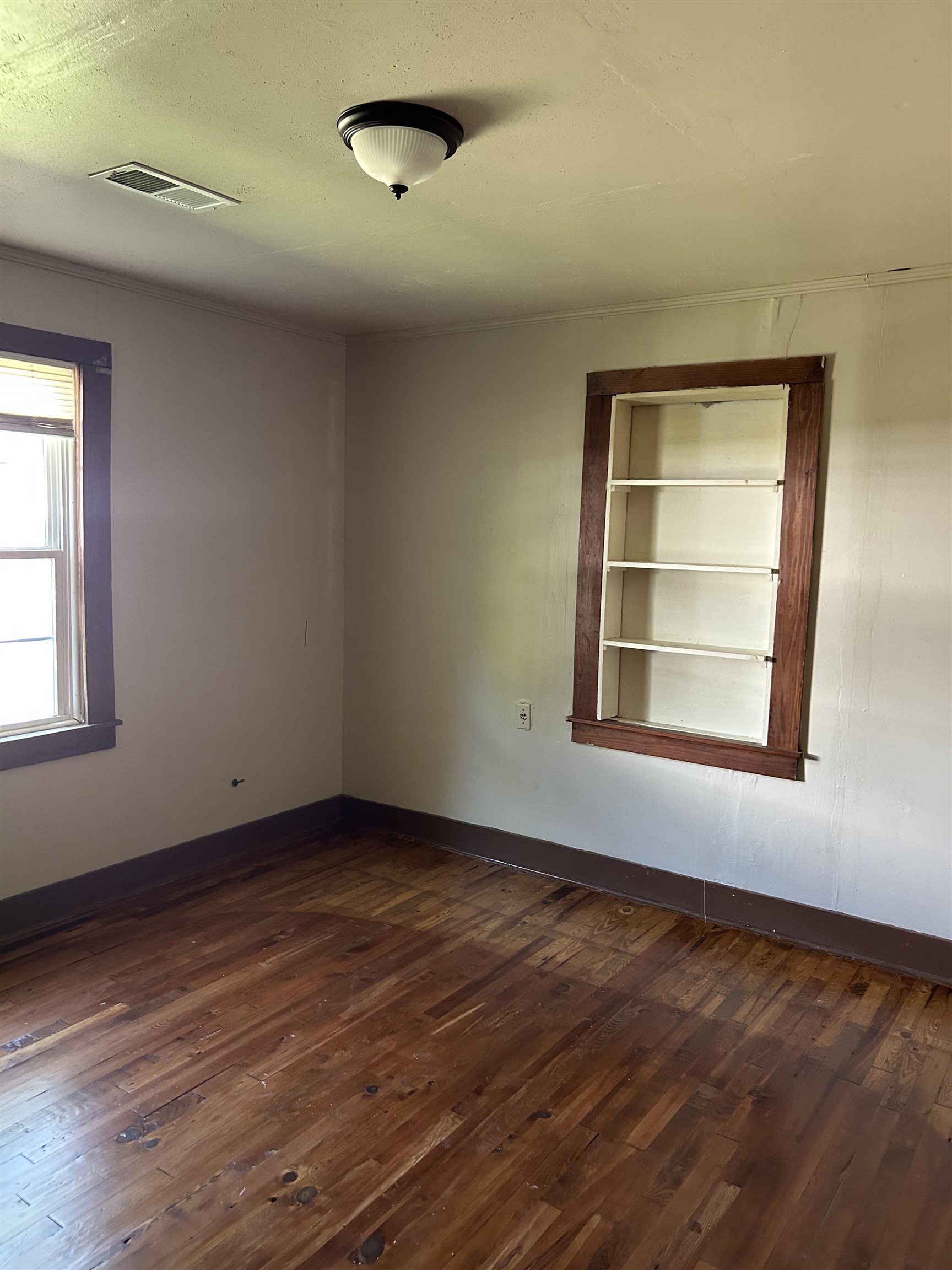 124 East Ripley Avenue Covington, TN 38019 - Photo 5 of 9 Empty room featuring dark wood finished floors and a textured ceiling
