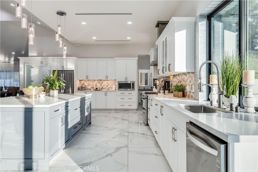 3890 Shadow Grove Road Pasadena, CA 91107 - Photo 16 of 63 a kitchen with kitchen island granite countertop lots of white cabinets and white appliances