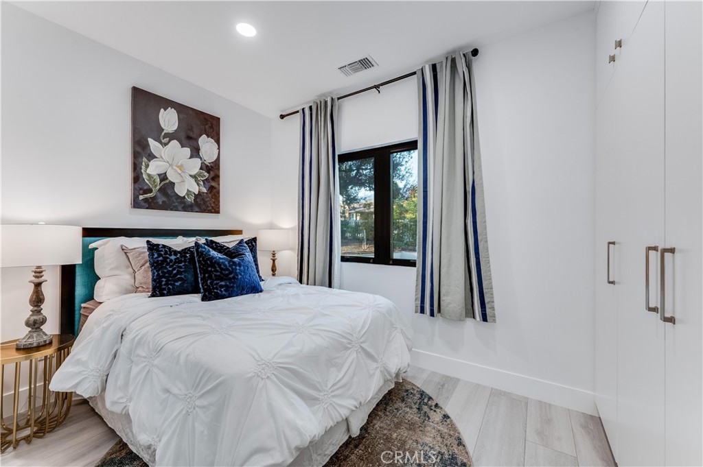 3890 Shadow Grove Road Pasadena, CA 91107 - Photo 9 of 63 a bedroom with a large bed and a painting on the wall