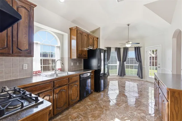 a kitchen with stainless steel appliances granite countertop a stove a sink dishwasher a refrigerator and a microwave