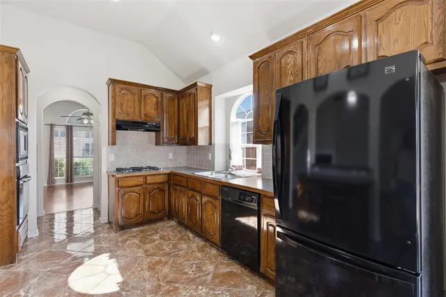 a kitchen with stainless steel appliances granite countertop a refrigerator and a sink