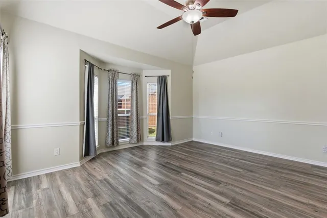 a view of a livingroom with wooden floor and a ceiling fan