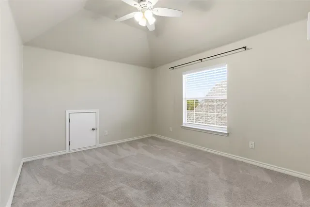 an empty room with fan and windows